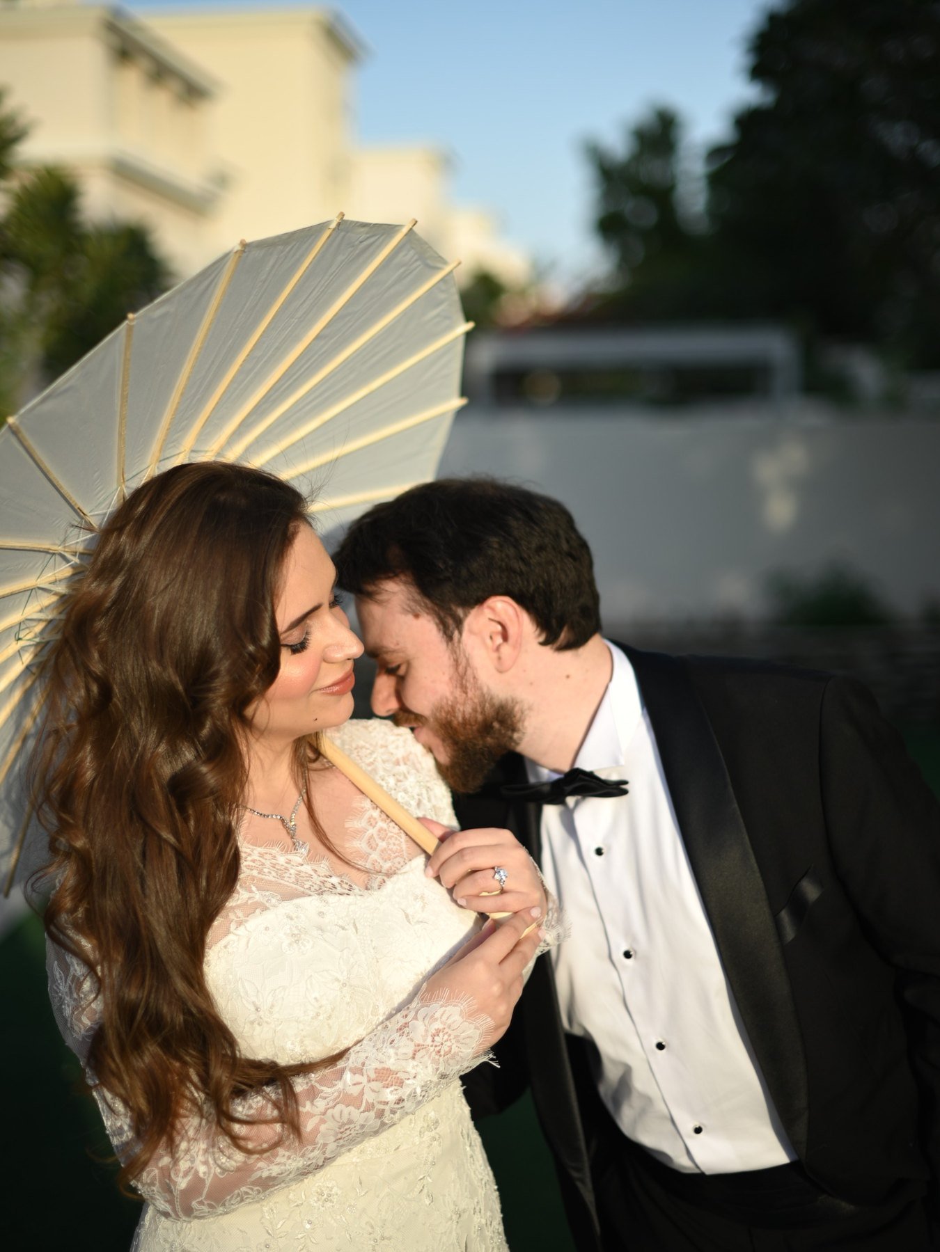 Bride with parasol and groom in soft afternoon light